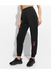 JOANNA MUZYK - Czarne spodnie dresowe z różowym logo. Stan: obniżony. Kolor: czarny. Materiał: dresówka