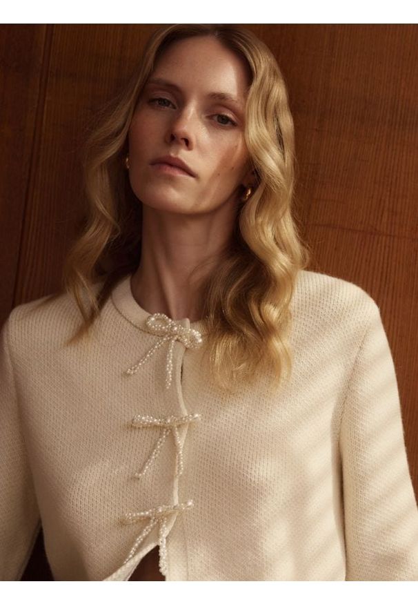 Reserved - Kardigan z kokardami - kremowy. Typ kołnierza: kokarda. Kolor: kremowy. Materiał: wełna, dzianina