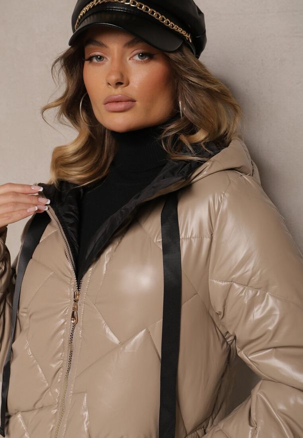 Renee - Ciemnobeżowa Kurtka Pikowana o Długim Kroju z Kapturem Ozdobiona Sznurkami Polezi. Okazja: na co dzień. Typ kołnierza: kaptur. Kolor: beżowy. Materiał: jeans. Długość: długie. Wzór: aplikacja. Styl: casual