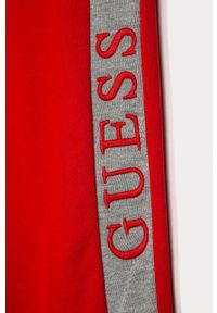 Guess Jeans - Spodnie dziecięce 116-175. Kolor: czerwony. Materiał: bawełna, jeans, dzianina. Wzór: aplikacja #3