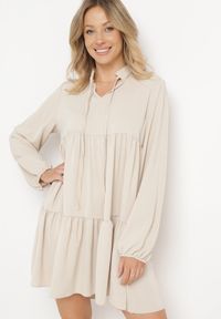 Born2be - Beżowa Rozkloszowana Sukienka z Falbanką Uxaria. Typ kołnierza: kołnierz z falbankami. Kolor: beżowy. Długość rękawa: długi rękaw. Wzór: aplikacja. Styl: elegancki #1
