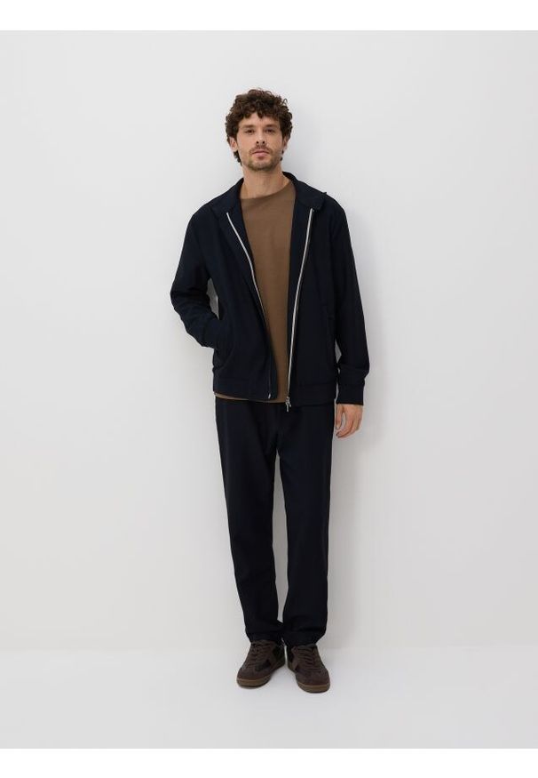 Reserved - Spodnie joggery - granatowy. Kolor: niebieski. Materiał: tkanina. Wzór: gładki