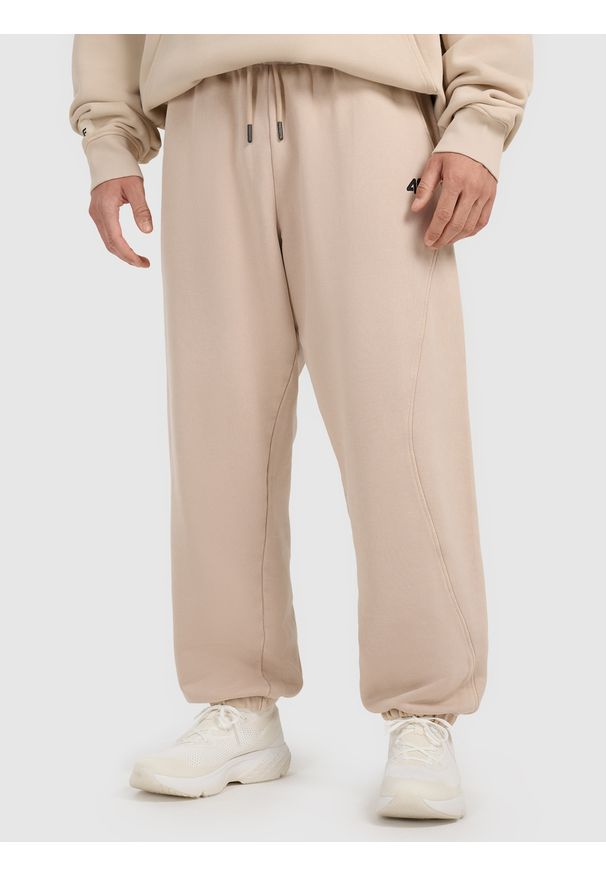 4f - 4F Spodnie dresowe joggery męskie 4F x Tomasz Fornal - beżowe M. Kolor: beżowy. Materiał: dresówka. Wzór: aplikacja. Sport: fitness