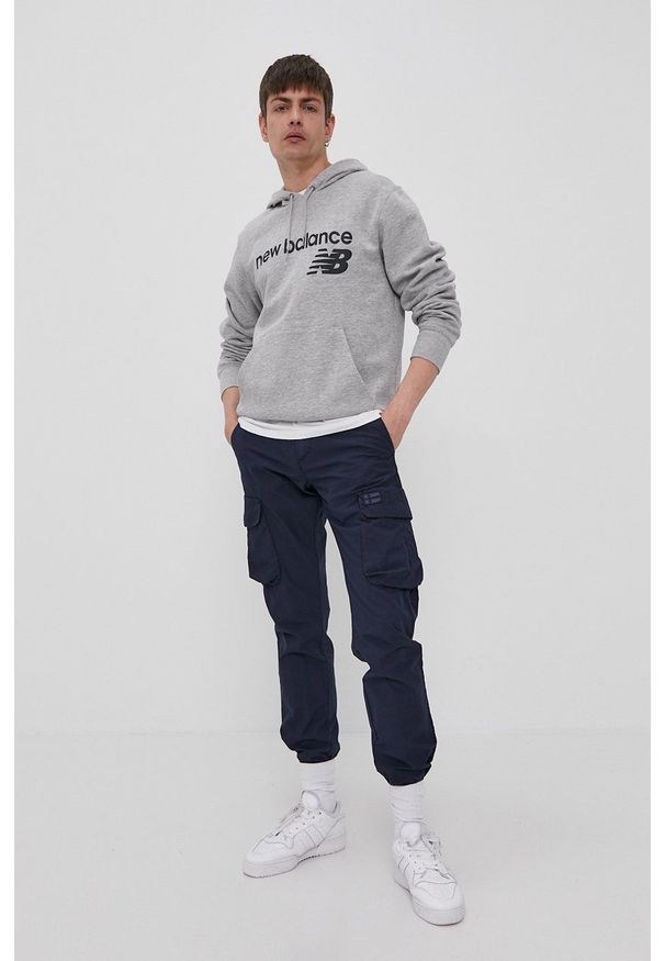 New Balance Bluza MT03910AG męska kolor szary z kapturem z nadrukiem. Okazja: na co dzień. Typ kołnierza: kaptur. Kolor: szary. Wzór: nadruk. Styl: casual