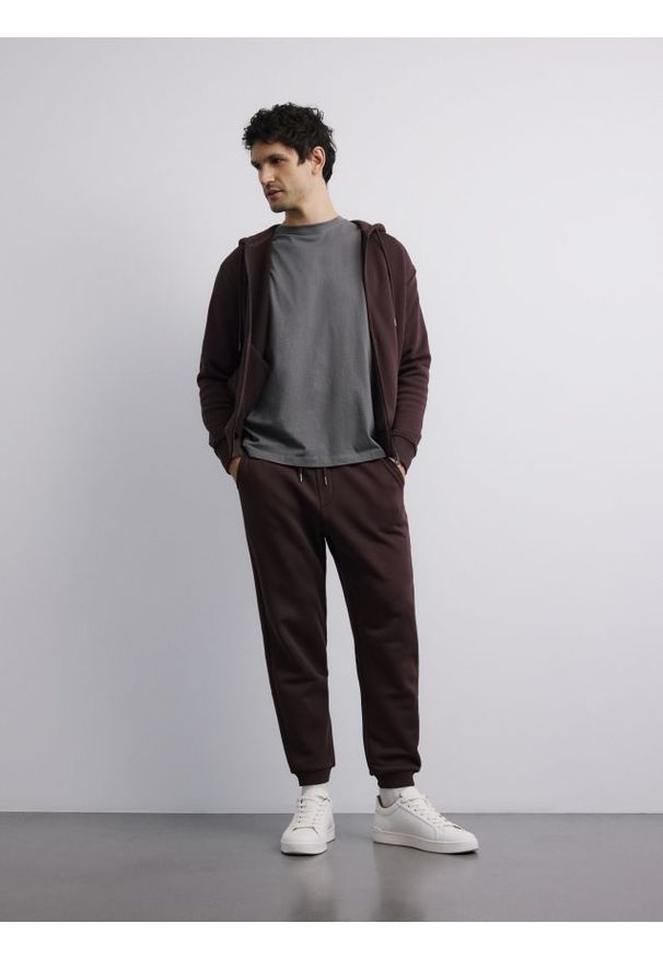 Reserved - Spodnie dresowe regular fit - ciemnobrązowy. Kolor: brązowy. Materiał: dresówka