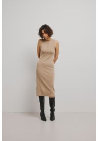 Marsala - Dopasowana sukienka bez rękawów w kolorze BEIGE - TARMA-L. Okazja: na co dzień. Materiał: dzianina, lyocell, elastan. Długość rękawa: bez rękawów. Wzór: prążki. Typ sukienki: proste. Styl: klasyczny, elegancki, casual. Długość: midi