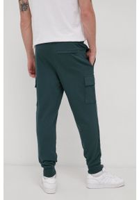 Puma - Spodnie. Kolor: zielony. Materiał: dzianina. Wzór: nadruk #2