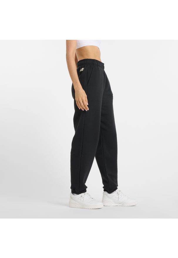 Spodnie damskie New Balance WP51500BK – czarne. Stan: podwyższony. Kolor: czarny. Materiał: bawełna, dresówka, poliester