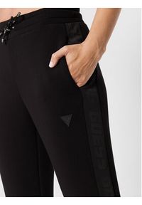 Guess Spodnie dresowe V2YB18 K7UW2 Czarny Regular Fit. Kolor: czarny. Materiał: dresówka, wiskoza