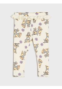 Sinsay - Prążkowane legginsy z falbanką Disney - kremowy. Kolor: kremowy. Materiał: prążkowany. Wzór: motyw z bajki #1