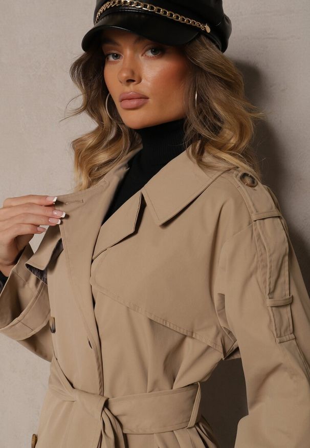 Renee - Ciemnobeżowy Płaszcz Trencz o Dwurzędowym Kroju z Rozcięciem i Klapą Wiązany w Talii Valezi. Okazja: na co dzień, do pracy, na spacer. Kolor: beżowy. Materiał: dzianina, skóra, jeans. Długość rękawa: długi rękaw. Długość: długie. Wzór: aplikacja. Styl: casual, elegancki