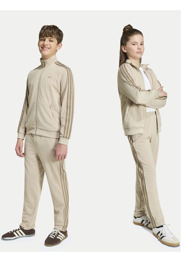 Adidas - adidas Spodnie dresowe Firebird HZ6652 Beżowy jasny Regular Fit. Kolor: beżowy. Materiał: syntetyk