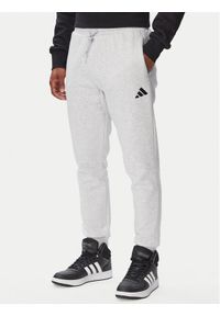 Adidas - adidas Spodnie dresowe Essentials Feelcozy Fleece JE3819 Szary jasny Regular Fit. Kolor: szary. Materiał: bawełna #1