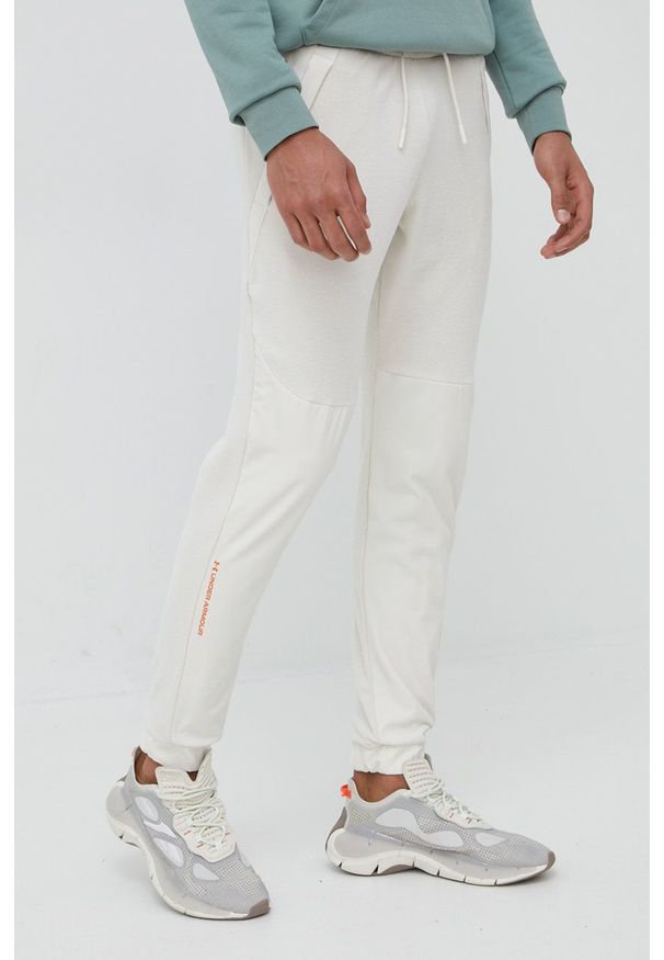 Under Armour spodnie dresowe 1366179 męskie kolor beżowy joggery. Kolor: beżowy. Materiał: dresówka