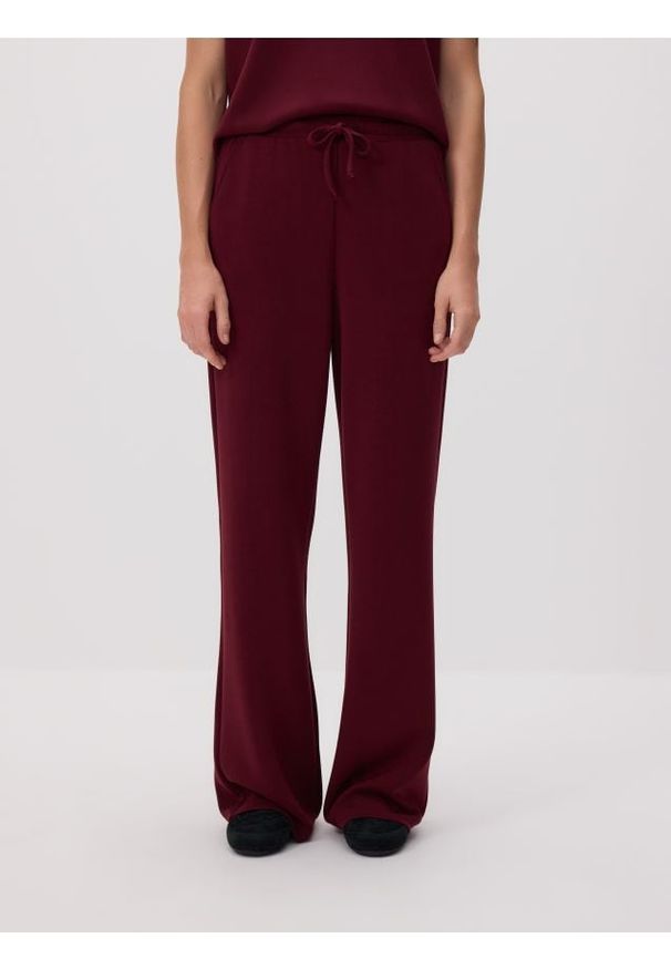 Reserved - Spodnie long leg - bordowy. Kolor: czerwony. Materiał: dzianina