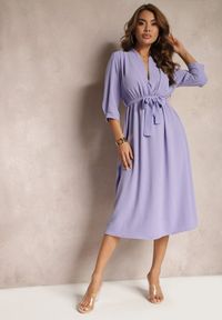 Renee - Jasnofioletowa Sukienka Canopis. Typ kołnierza: dekolt kopertowy. Kolor: fioletowy. Materiał: tkanina, materiał. Typ sukienki: kopertowe. Styl: elegancki. Długość: midi