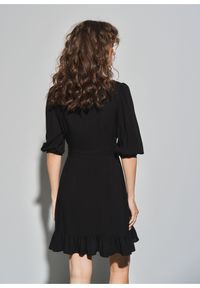 Ochnik - Czarna sukienka z falbanką. Kolor: czarny. Materiał: wiskoza. Typ sukienki: rozkloszowane, asymetryczne. Długość: mini
