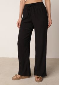 Born2be - Czarne Szerokie Spodnie z Teksturalnej Tkaniny z Wiązaniem w Pasie Agatia. Okazja: do pracy, na co dzień, na spacer. Stan: podwyższony. Kolor: czarny. Materiał: tkanina. Długość: długie. Styl: wakacyjny, casual #4