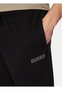 Guess Spodnie dresowe Z4YB00 KAIJ1 Czarny Relaxed Fit. Kolor: czarny. Materiał: bawełna