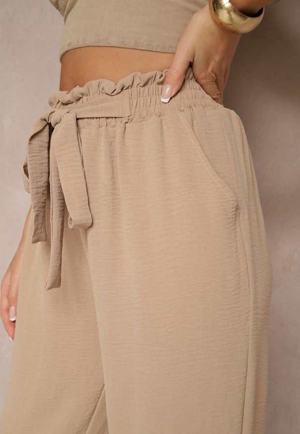Renee - Ciemnobeżowe Spodnie High Waist Ozdobione Wiązanym Paskiem Araleira. Okazja: na co dzień, na spacer. Stan: podwyższony. Kolor: beżowy. Materiał: jedwab. Długość: długie. Wzór: aplikacja. Sezon: wiosna. Styl: casual