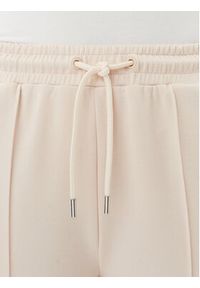 Guess Spodnie dresowe V5RB19 KCOB2 Beżowy Regular Fit. Kolor: beżowy. Materiał: syntetyk