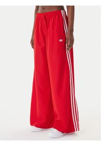 Adidas - adidas Spodnie dresowe Firebird Adilenium KD6299 Czerwony Regular Fit. Kolor: czerwony. Materiał: syntetyk #1