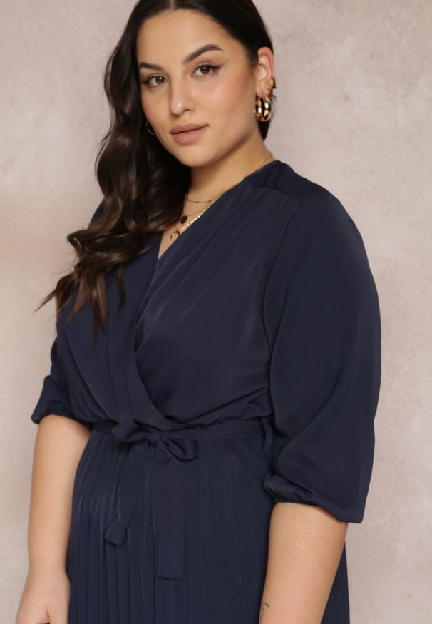 Renee - Granatowa Kopertowa Sukienka z Gumką i Paskiem w Talii Zdobiona Plisowaniem Kaylina. Kolekcja: plus size. Kolor: niebieski. Wzór: aplikacja. Typ sukienki: kopertowe