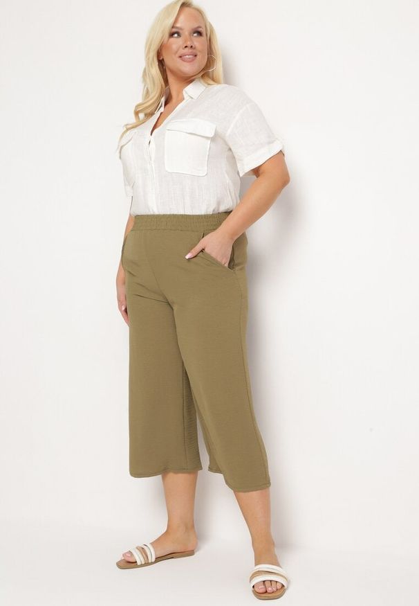 Born2be - Ciemnozielone Szerokie Spodnie z Wysokim Stanem z Gumką w Talii i Nogawkami Długości 3/4 Levolia. Okazja: na co dzień. Stan: podwyższony. Kolekcja: plus size. Kolor: zielony. Materiał: jedwab. Styl: casual, elegancki