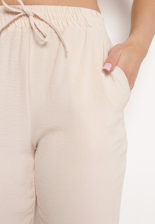 Born2be - Jasnobeżowe Spodnie Wiązane Troczkiem w Pasie ze Zwężającymi się Nogawkami Starila. Okazja: na co dzień. Kolor: beżowy. Materiał: len. Styl: elegancki, wakacyjny, casual