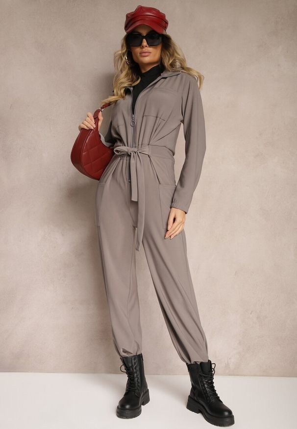 Renee - Szary Kombinezon z Elastyczną Gumką w Pasie z Dodatkowym Wiązaniem o Luźnym Kroju Creera. Okazja: na co dzień. Kolor: szary. Materiał: tkanina. Styl: casual