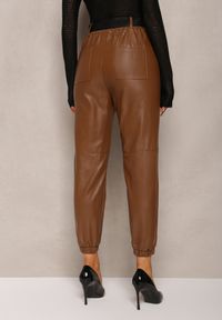 Renee - Brązowe Spodnie Joggery z Imitacji Skóry z Paskiem z Klamrą Mittara. Kolor: brązowy. Materiał: skóra