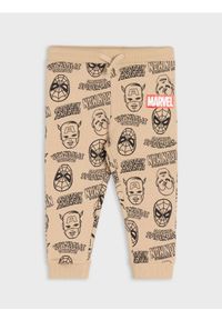 Sinsay - Spodnie dresowe jogger ze wzorem Marvel - beżowy. Kolor: beżowy. Materiał: dresówka. Wzór: motyw z bajki #1