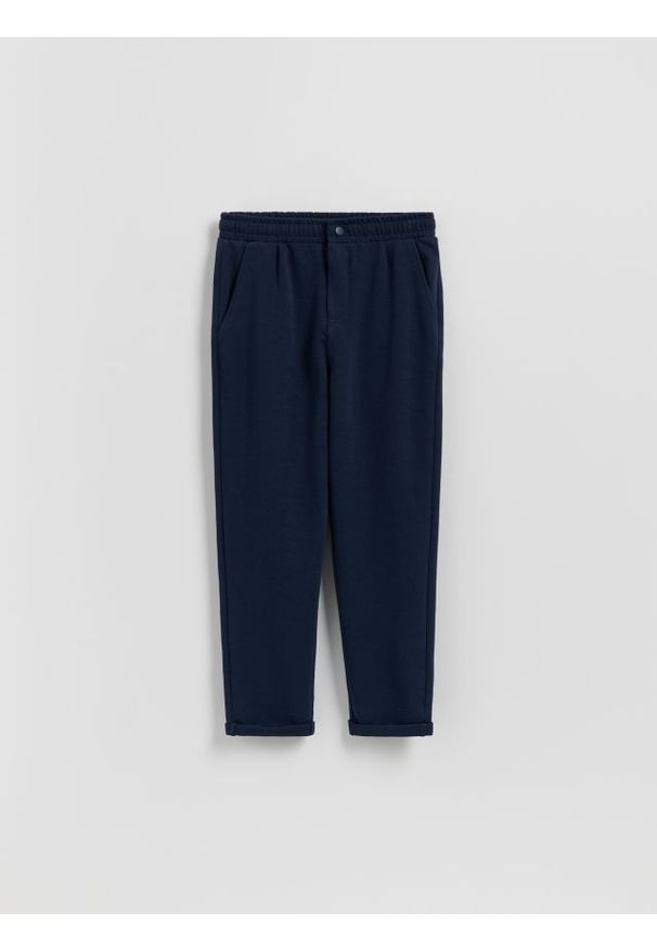 Reserved - BOYS` TROUSERS - granatowy. Kolor: niebieski. Materiał: dzianina, bawełna