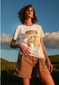 Volcano - Biała koszulka damska T-MOTIV ze złotym nadrukiem. Kolekcja: plus size. Kolor: biały. Materiał: bawełna, elastan. Długość rękawa: krótki rękaw. Długość: krótkie. Wzór: nadruk. Styl: klasyczny, elegancki, glamour