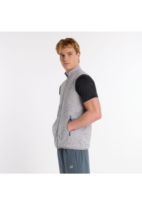 Bezrękawnik męski New Balance MV51200AG – szary. Okazja: na co dzień. Typ kołnierza: kołnierzyk stójkowy. Kolor: czarny. Materiał: skóra, materiał, tkanina, poliester. Długość rękawa: bez rękawów. Wzór: aplikacja. Styl: casual, klasyczny