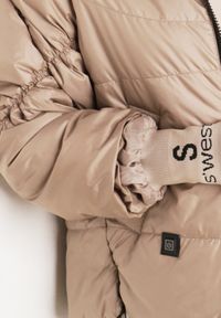 Born2be - Ciemnobeżowa Przejściowa Kurtka Pikowana z Kapturem i Napisami na Rękawach Althone. Okazja: na co dzień. Typ kołnierza: kaptur. Kolor: beżowy. Materiał: poliester. Wzór: napisy. Styl: casual #7