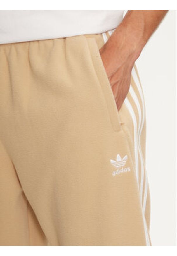 Adidas - adidas Spodnie dresowe adicolor 3-Stripes IZ2490 Beżowy Regular Fit. Kolor: beżowy. Materiał: syntetyk