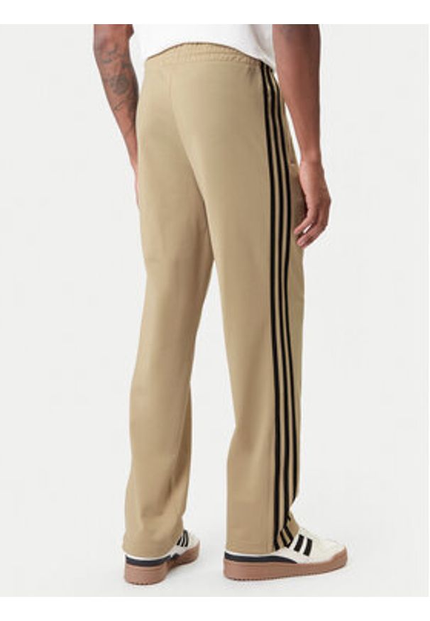 Adidas - adidas Spodnie dresowe Firebird KE6679 Beżowy Loose Fit. Kolor: beżowy. Materiał: syntetyk