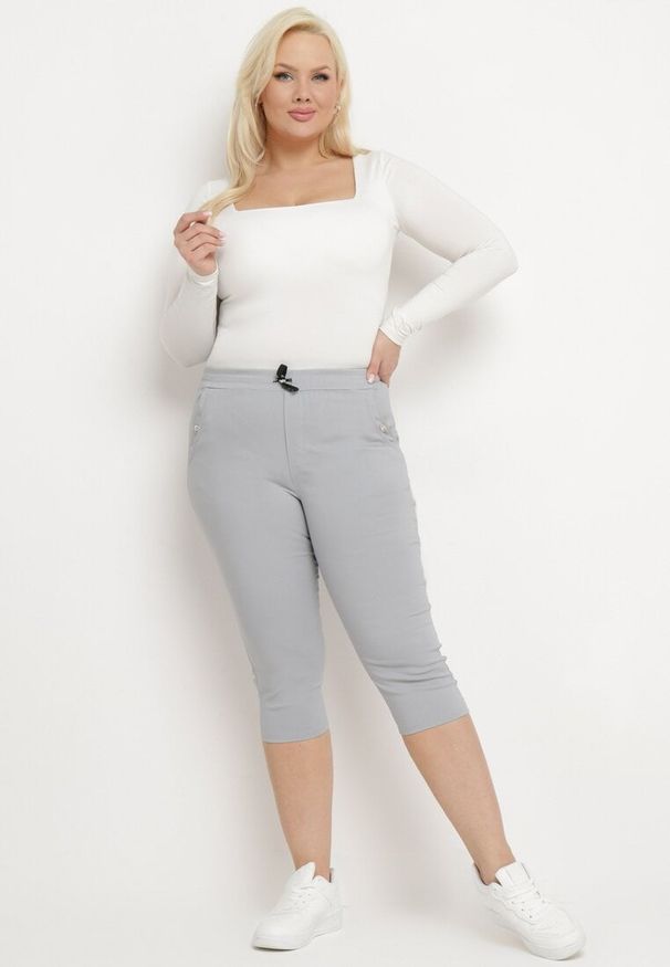 Born2be - Jasnoszare Spodnie 3/4 z Gumką w Pasie i Troczkiem Ozdobione Cyrkoniami Nazairia. Okazja: na co dzień. Kolor: szary. Wzór: aplikacja. Styl: casual