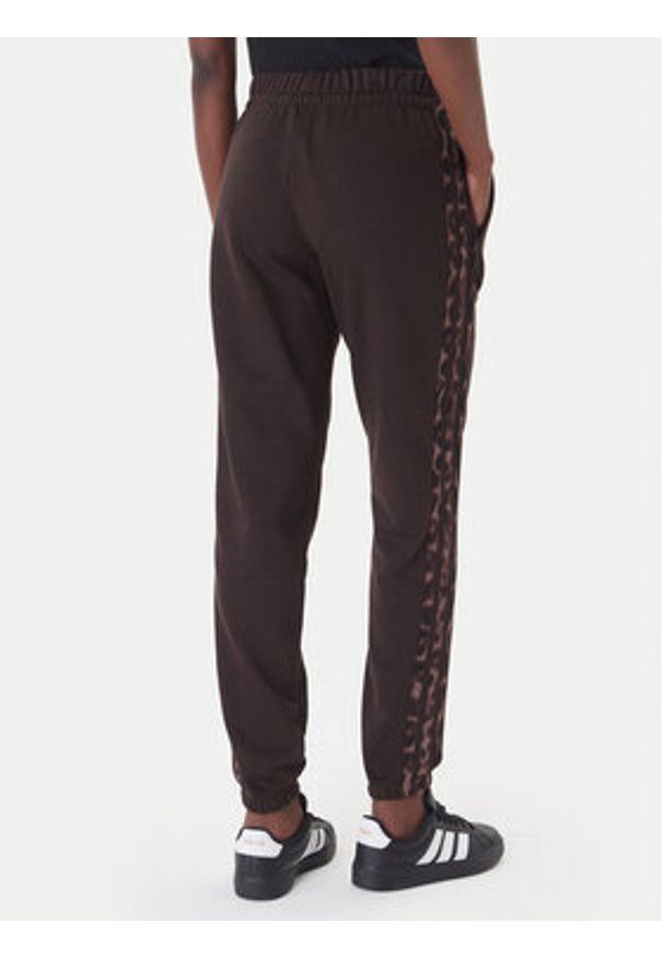 Adidas - adidas Spodnie dresowe Seasonal Essentials Leopard Print KA4720 Brązowy Regular Fit. Kolor: brązowy. Materiał: bawełna. Wzór: nadruk