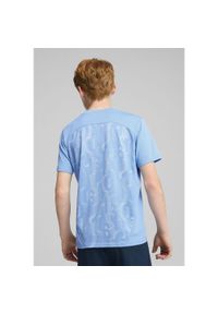 Puma - Młodzieżowa koszulka przedmeczowa z krótkim rękawem Manchester City PUMA. Kolor: biały, wielokolorowy, niebieski. Długość rękawa: krótki rękaw. Długość: krótkie