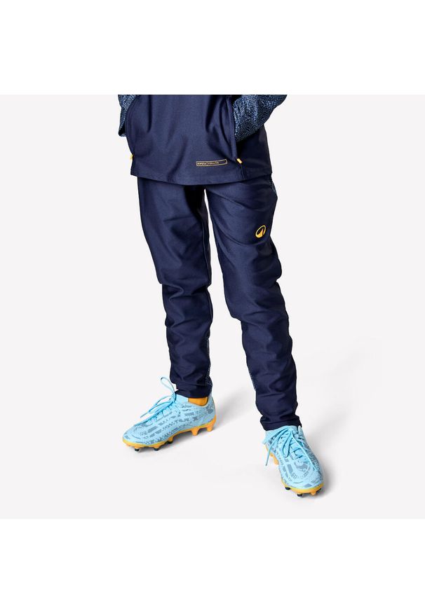 KIPSTA - Spodnie piłkarskie dla dzieci Kipsta Viralto. Kolor: żółty, niebieski, wielokolorowy, pomarańczowy. Materiał: poliester, materiał, elastan. Sport: piłka nożna