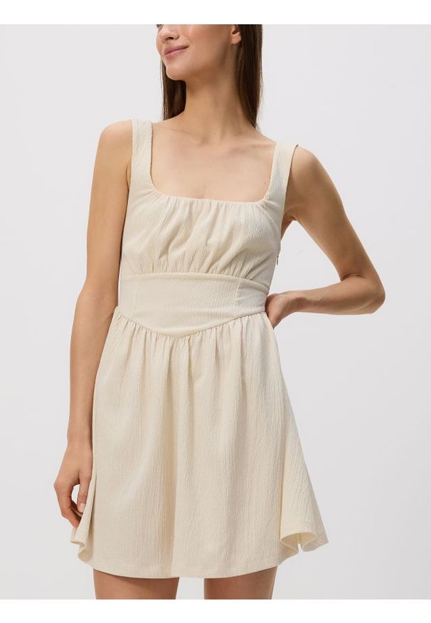 Reserved - Kreszowana sukienka mini - kremowy. Kolor: kremowy. Materiał: dzianina. Długość: mini