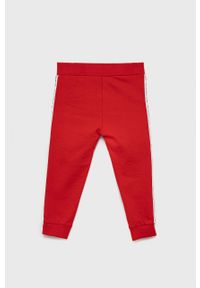 Guess - Spodnie bawełniane dziecięce. Okazja: na co dzień. Kolor: czerwony. Materiał: bawełna. Styl: casual