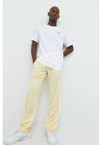adidas Originals spodnie dresowe męskie kolor żółty gładkie. Kolor: żółty. Materiał: dresówka. Wzór: gładki