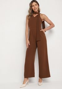 Born2be - Brązowy Kombinezon Bez Rękawów z Ozdobnym Wiązaniem i Szerokimi Nogawkami Silarine. Okazja: na co dzień. Kolor: brązowy. Materiał: jeans. Długość rękawa: bez rękawów. Styl: sportowy, klasyczny, casual, elegancki #1