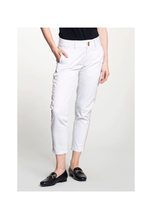 Ochnik - Białe spodnie damskie z lampasem. Kolor: biały. Materiał: bawełna. Wzór: aplikacja. Sezon: lato. Styl: elegancki