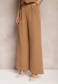 Renee - Brązowe Eleganckie Spodnie Dzwony z Ozdobnymi Patkami w Pasie Nattas. Stan: podwyższony. Kolor: brązowy. Styl: elegancki