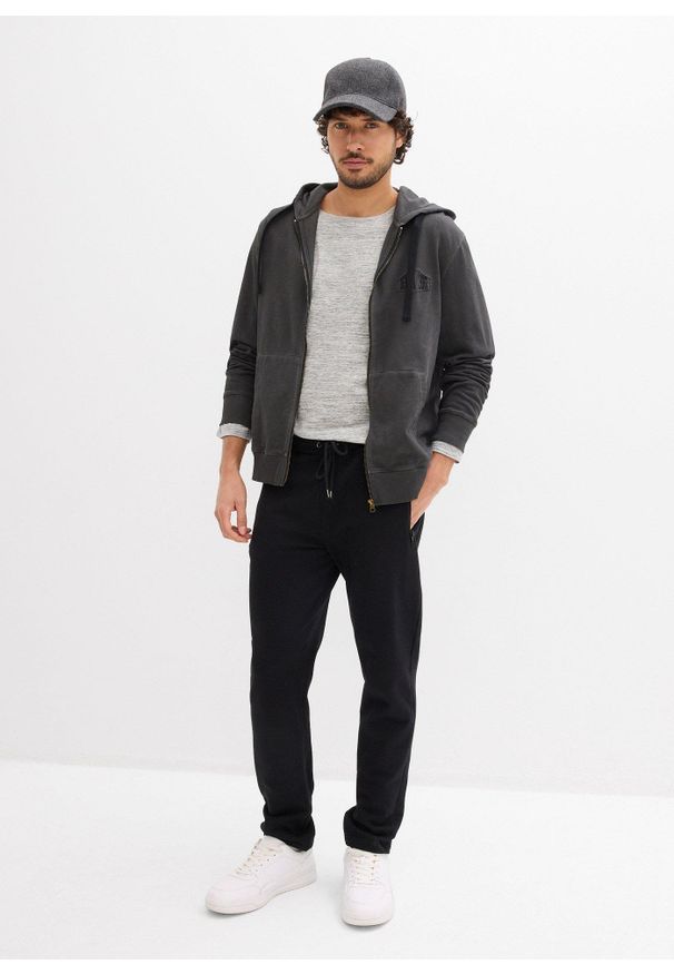 bonprix - Spodnie sportowe z praktycznymi kieszeniami zapinanymi na zamek. Kolor: czarny. Styl: sportowy