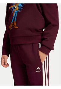Adidas - adidas Spodnie dresowe Pixar Toy Story KG6131 Bordowy Regular Fit. Kolor: czerwony. Materiał: bawełna. Wzór: motyw z bajki #5